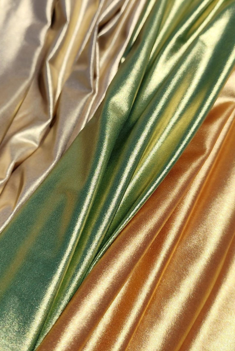 Metallic swimwear fabrics from the Lumière Collection by Nora Chantre in light gold, olive green and copper tones.