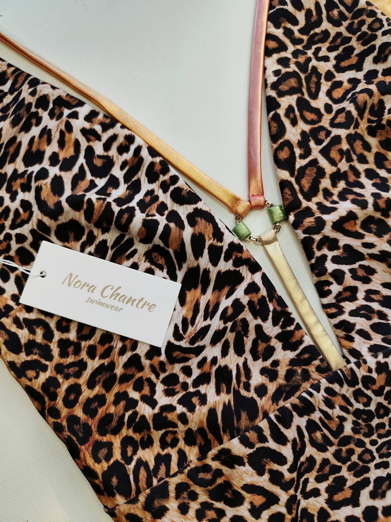 Leopard print swimsuit detail with gold ring accessory and metallic straps