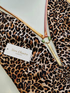 Leopard print swimsuit detail with gold ring accessory and metallic straps