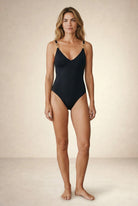 Black one piece swimsuit Aurelia by Nora Chantre with gold strap detail front view