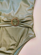 Close-up detail of the crocodile texture fabric and belt ring on the Elara swimsuit by Nora Chantre.
