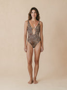 Front view of leopard print one-piece swimsuit by Nora Chantre with deep neckline and central gold detail.