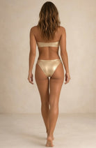 Back view of the Lumière light gold metallic bikini with moderate coverage by Nora Chantre.