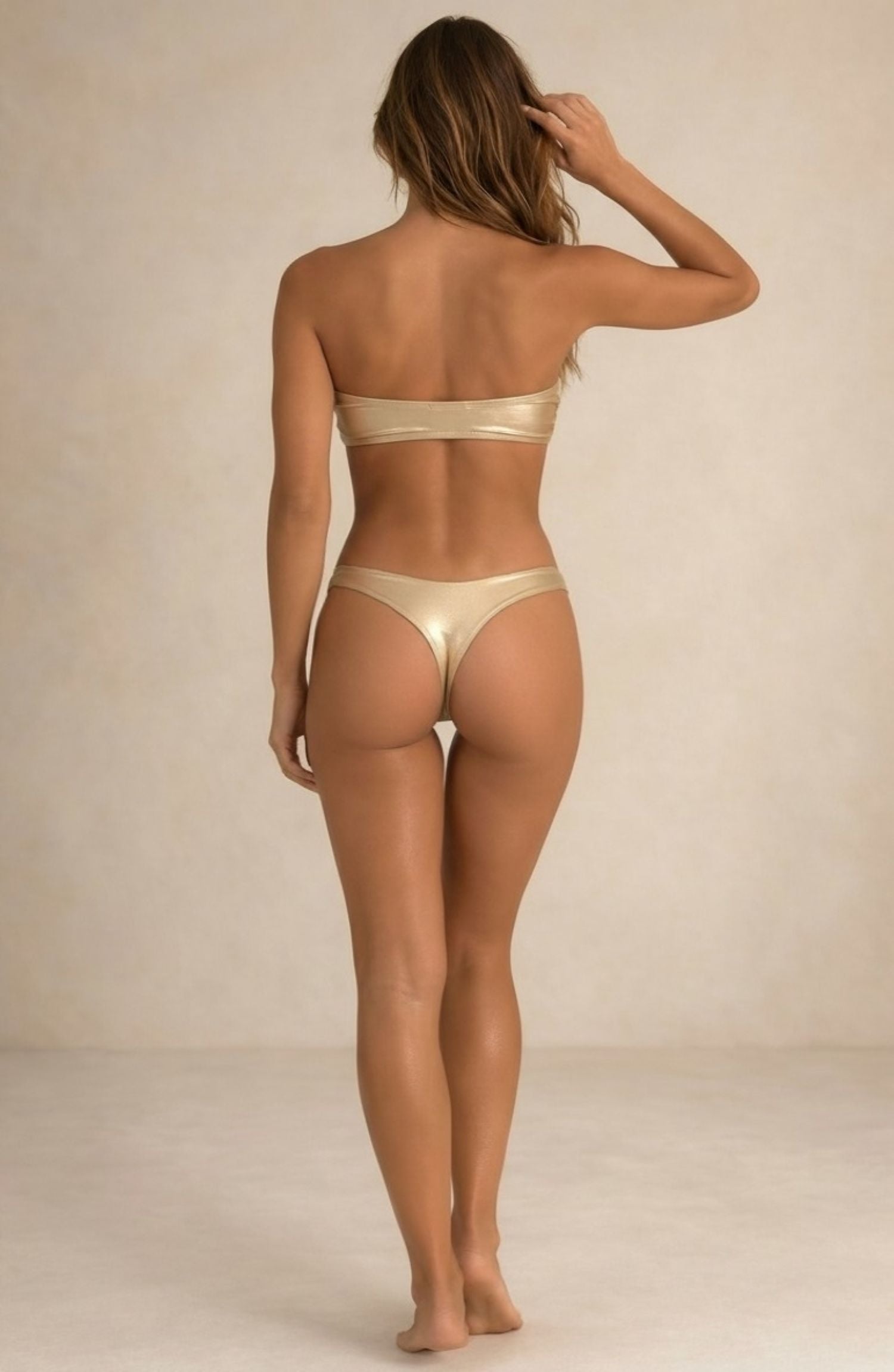 Back view of the Lumière light gold metallic bikini with thong coverage by Nora Chantre.