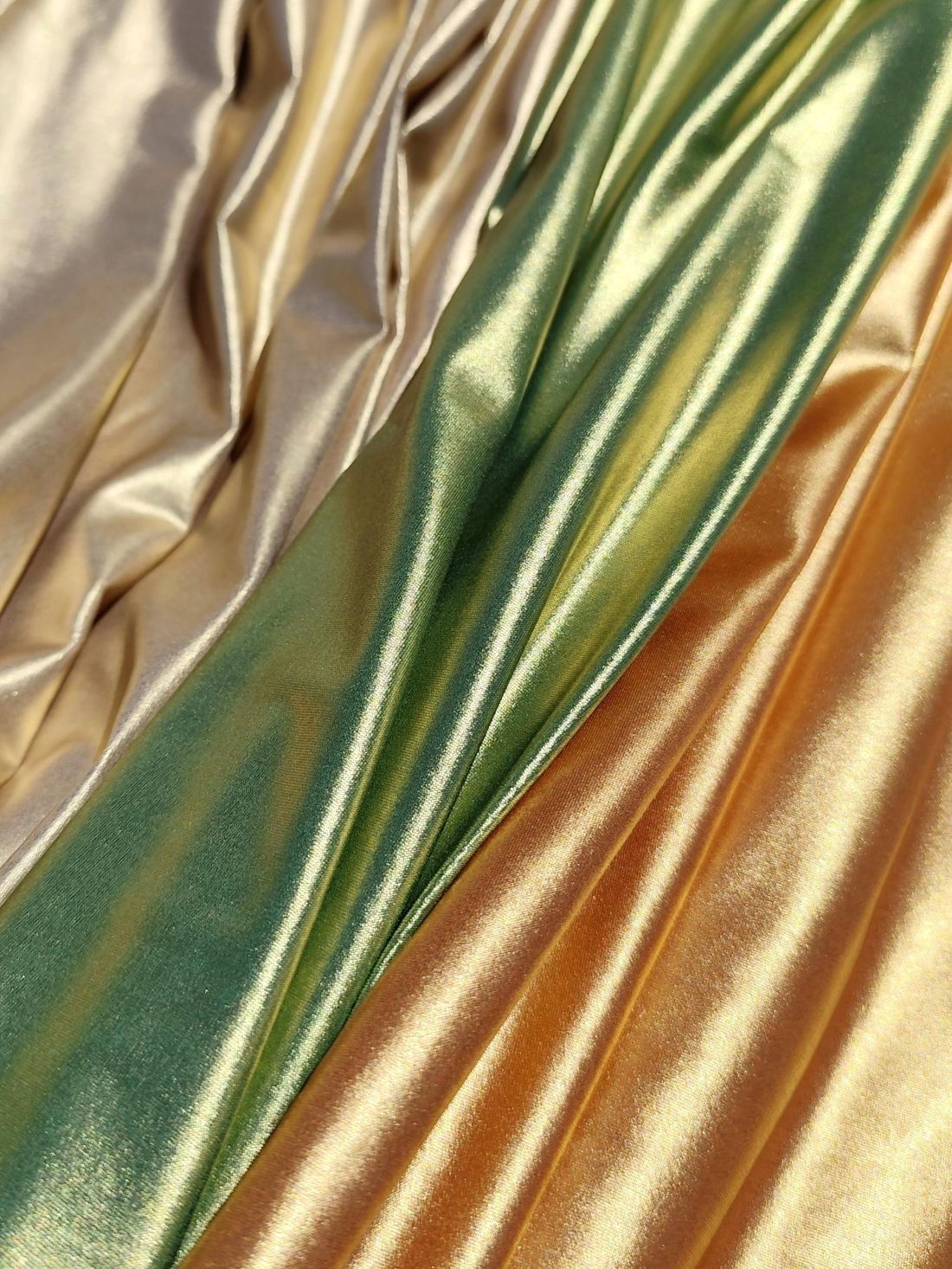 Metallic swimwear fabrics from the Lumière Collection by Nora Chantre in light gold, olive green and copper tones.