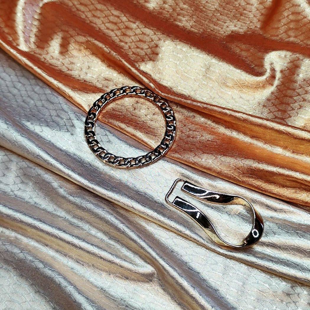 Detalle de tejido metálico con textura y accesorios dorados de alta calidad para swimwear