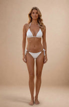 Pearl white triangle bikini with gold bead details on straps and adjustable tie sides, front view on model